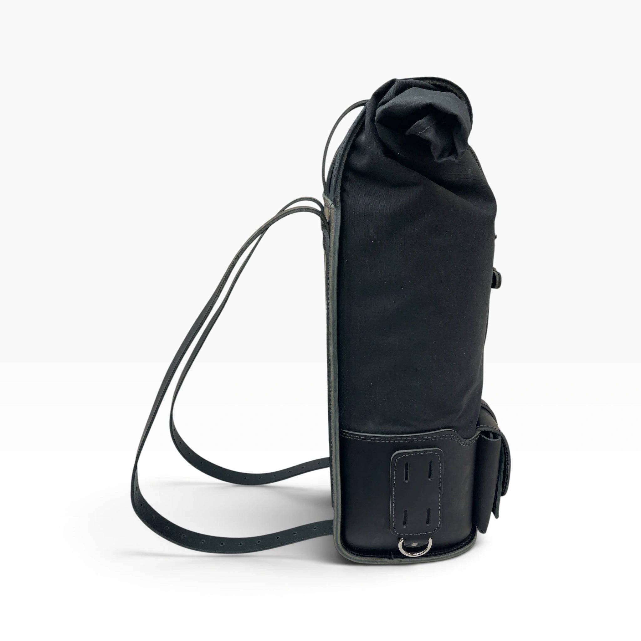 A black roll-top backpack with a long shoulder strap, shown from a side profile view against a clean white background.