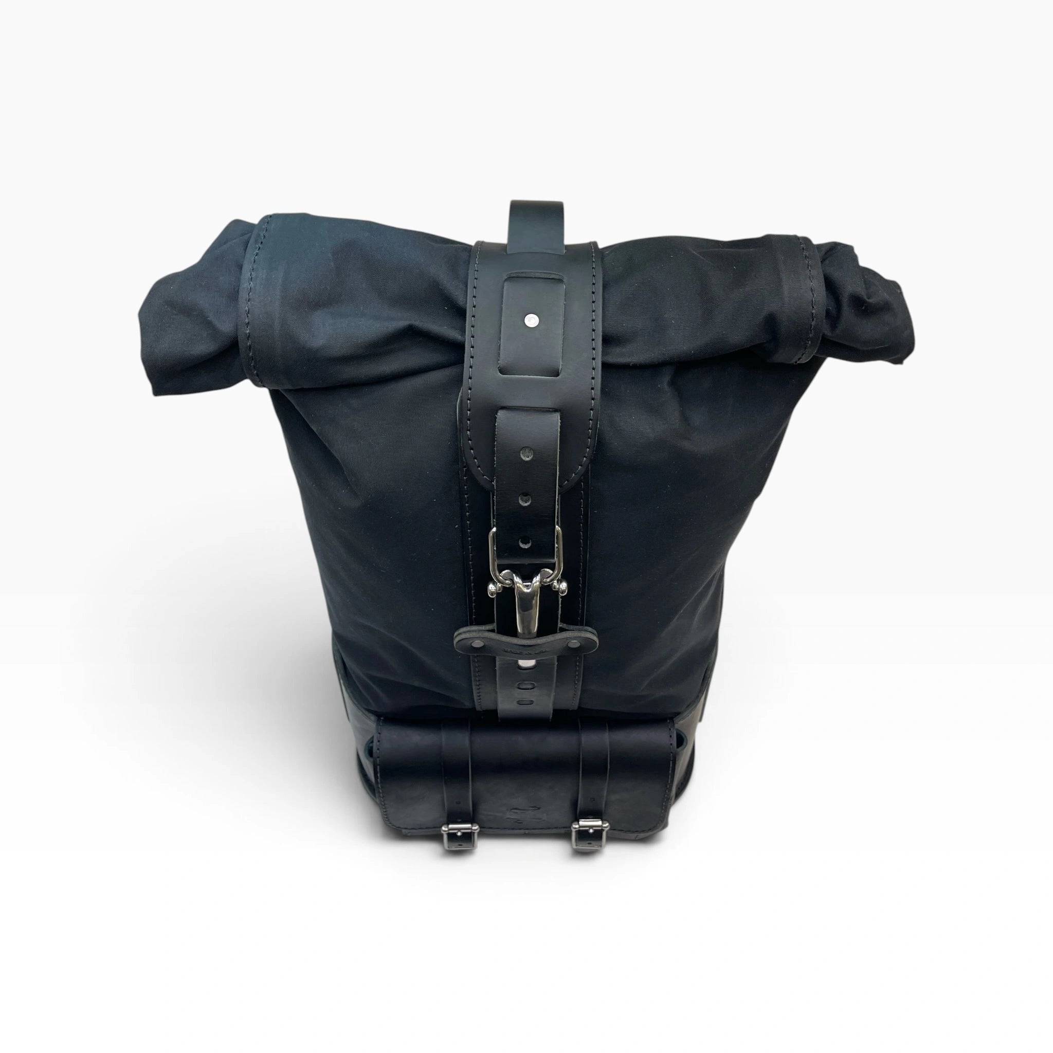 A black waterproof backpack with black leather straps and silver metal buckles, shown from the back on a white background.
